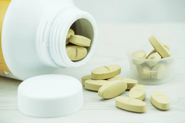 Brown pills an pill bottle on the table. — Stock Photo, Image