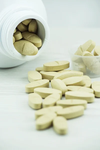 Brown pills an pill bottle on the table. — Stock Photo, Image