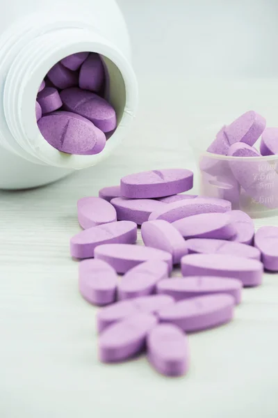 Violet pills an pill bottle on the table. — Stock Photo, Image