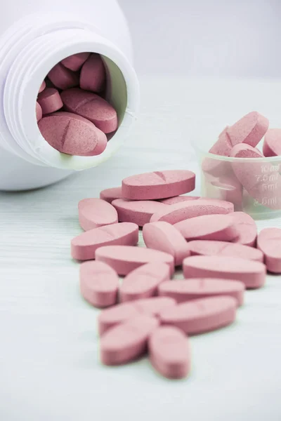 Pink pills an pill bottle on the table. — Stock Photo, Image