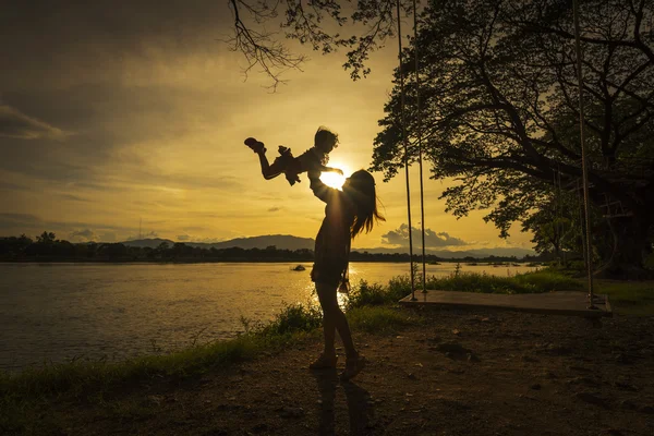 Anne ve kızı nehir yanında iskambil.