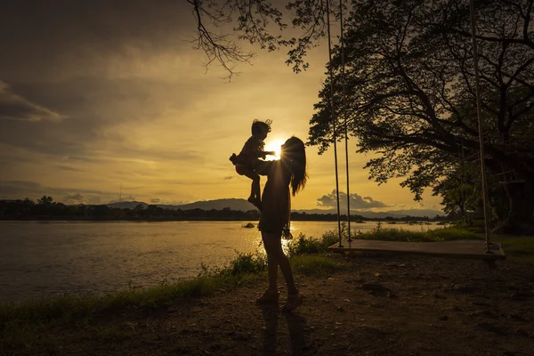 Anne ve kızı nehir yanında iskambil.