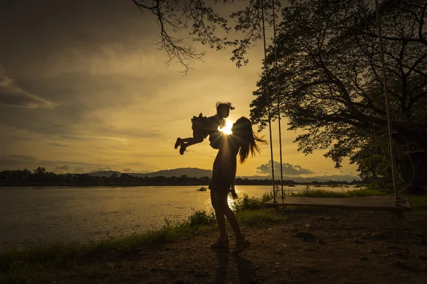 Anne ve kızı nehir yanında iskambil.