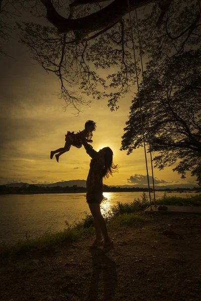 Mother and daughter playing at river side. — Stock Photo, Image