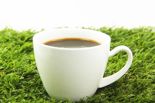 Una taza de café sobre hierba verde — Foto de Stock