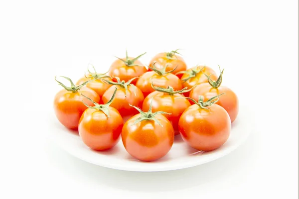 Tomaten mit grünem Blatt auf weißem Teller — Stockfoto