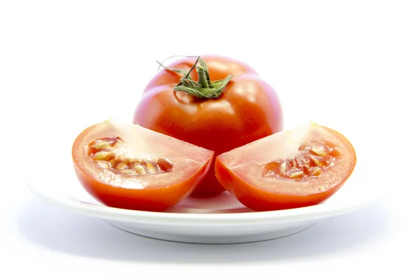 Tomatoes quarter sliced with raw material on plate — Stock Photo, Image