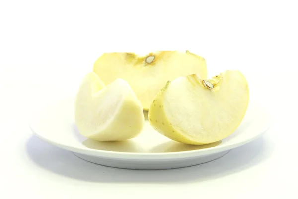 Obrać jabłko żółte na białym talerzu — Zdjęcie stockowe