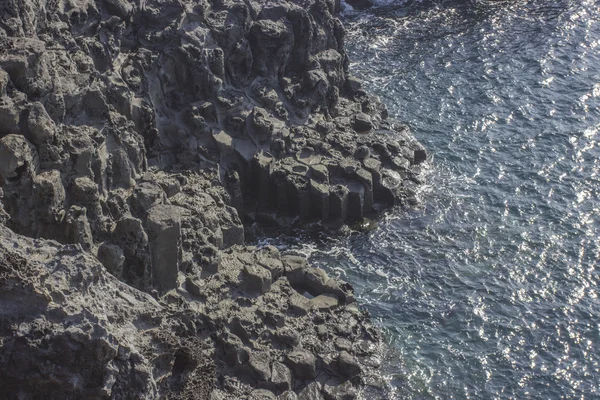 Black rock shape and form volcano island with ocean