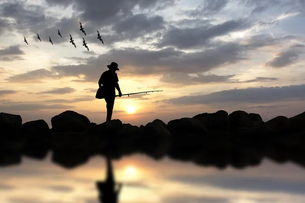 Silueta muže rybářský prut slunce pozadí. — Stock fotografie