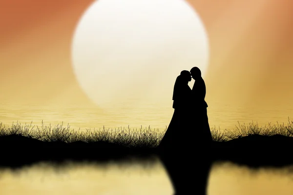 Silueta páru stojí na trávě Orange sky pozadí — Stock fotografie