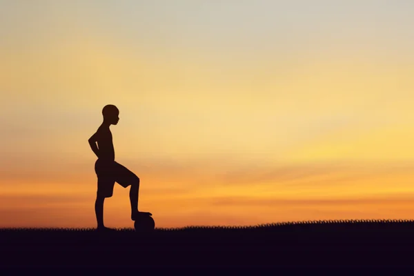 Silhueta de crianças jogando futebol fundo por do sol . — Fotografia de Stock