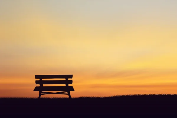 Σιλουέτα καρέκλα στο γρασίδι φόντο ηλιοβασίλεμα — Φωτογραφία Αρχείου