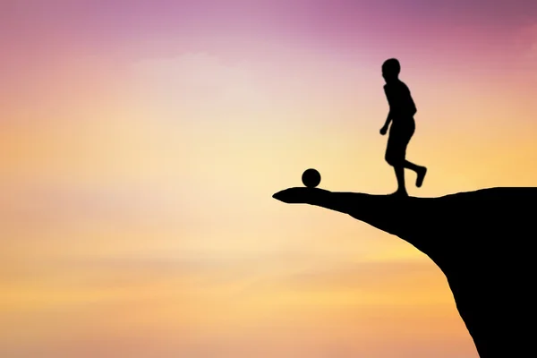Silhouette of children playing football on a cliff. — Stock Photo, Image