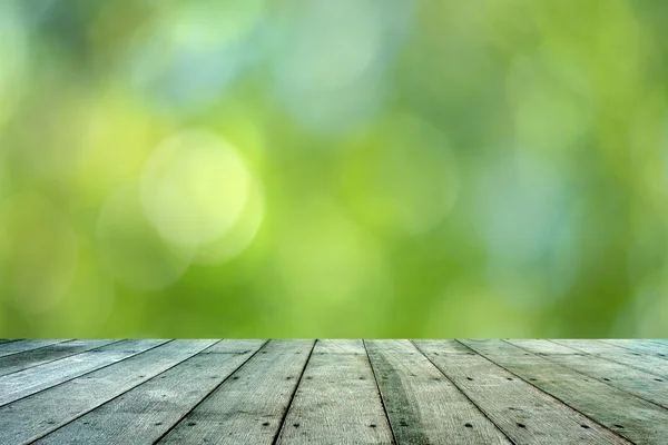 Leaf bokeh background with wooden paving. — Stock Photo, Image