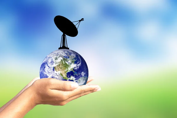 Satellite dish and earth in human hand. — Stock Photo, Image