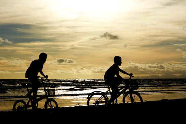儿童和自行车剪影在沙滩上. — 图库照片