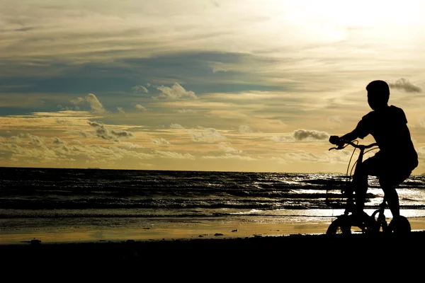 Children and bike silhouette on the sand beach. — Stock Photo, Image