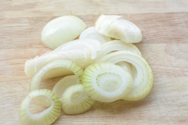 Cebollas en rodajas en un suelo de madera — Foto de Stock