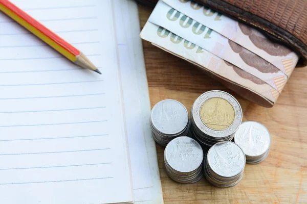 Concepto de ahorrar dinero, poner monedas en una taza en un piso de madera . —  Fotos de Stock