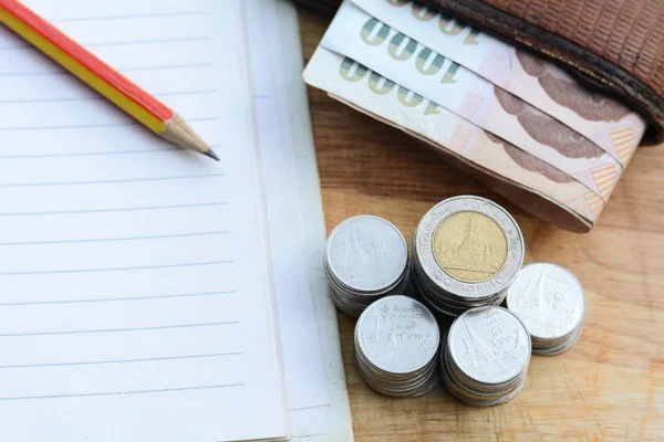 Concept van het besparen van geld, munten aanbrengend een cup op een houten vloer. — Stockfoto