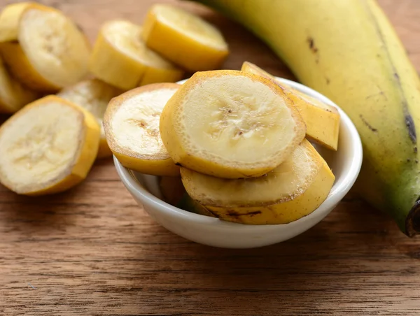 Gesneden bananen in een kopje over een tabel. — Stockfoto