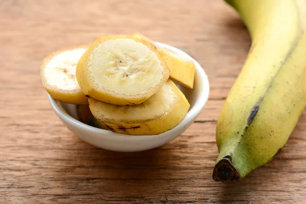 Gesneden bananen in een kopje over een tabel. — Stockfoto