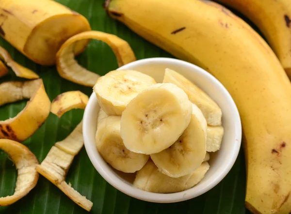 Gesneden bananen in een kopje over bananenblad — Stockfoto