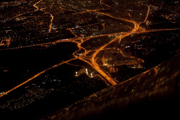 Blick aus dem Flugzeug auf die Stadt bei Nacht. Stockbild