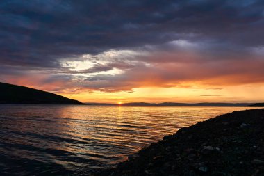     Bir yaz sabahı nehirde şafak vakti, bulutları turuncu-kırmızı tonlarda boyardı, suya yansıtırdı..                           