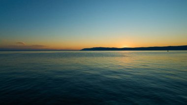 Sıcak bir yaz akşamında gölün arkasında gün batımı.                          