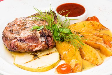 Patates dilimleri ve elma ile ızgara domuz biftek