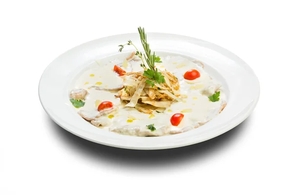 Pescado en una salsa cremosa con cebollas fritas y una ramita de verde en un plato blanco y un fondo blanco —  Fotos de Stock