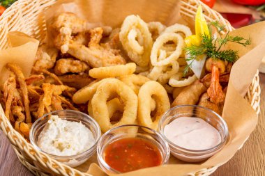 Bira aperatif. Karides, kalamar halkaları, soğan, kızarmış peynir, Sarımsak soslu tavuk kanatları