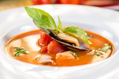 Domates çorbası dekore edilmiş deniz ürünleri fesleğen ile