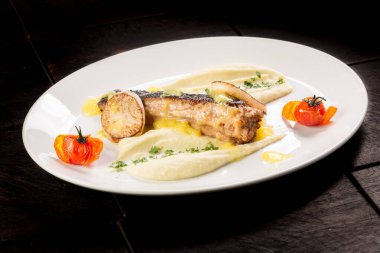 Kızarmış daikon ve patates püresi ile Karadeniz balığı bifteği.