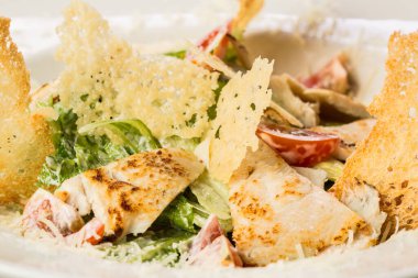 Parmesanlı tavuk ve kızarmış ekmek ile Sezar salatası.