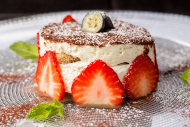 Fayjoa ve olgun çilekle süslenmiş cheesecake. 