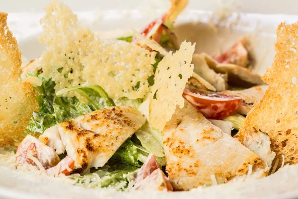 Parmesanlı tavuk ve kızarmış ekmek ile Sezar salatası.