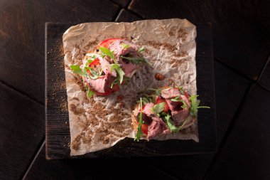 Biftek ve roka ile ahşap bir tahtanın üzerinde