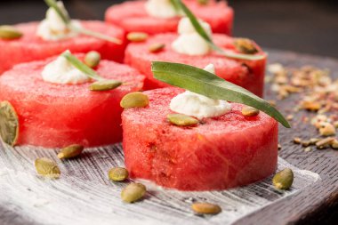 Karpuz, dilimlenmiş, tahta bir tahtada servis edilmiş, 5 parça.