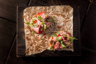 Biftek ve roka ile ahşap bir tahtanın üzerinde