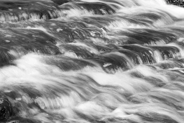 Hermoso fondo con el agua de un arroyo — Foto de Stock