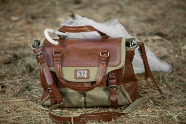 Vintage deri çanta ve beyaz şemsiye sararmış çimenlerin üzerinde