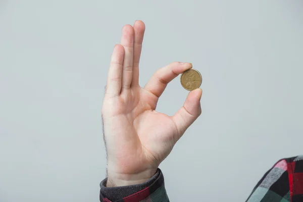 iki parmak, tamam işareti arasında yazı tura tutan adamın el