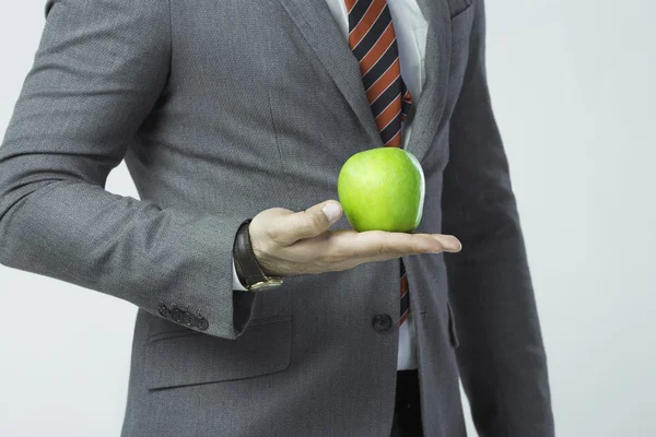 adamın elinde bir yeşil elma tutan