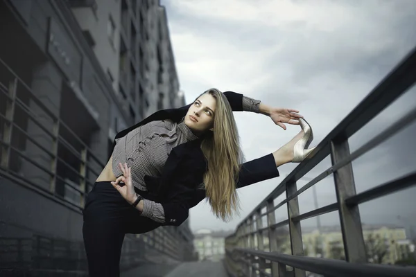 genç kızı pratik Yoga sokakta bir iş takım elbise giymiş