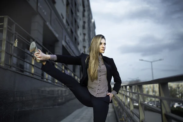 genç kızı pratik Yoga sokakta bir iş takım elbise giymiş