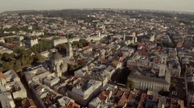 Şehir manzarası yukarıdan. Lviv, eski bir Avrupa şehri. Belediye binası, tapınaklar, kırmızı çatılı binalar ve güneşli bir günde sokaklar