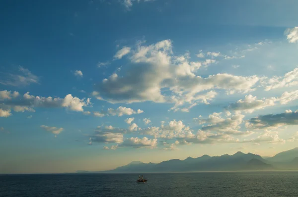 bulutlar ve arka planda bir gemi ile deniz manzarası